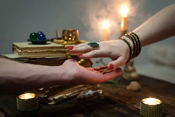 صورة تحتوي على يدين و شموع و كتاب 
اريد رقم شيخ روحاني صادق