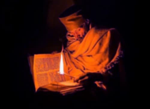 صورة تحتوي على شخص يمسك كتاباً في منتصفه شمعة رقم شيخ روحاني سعودي  
