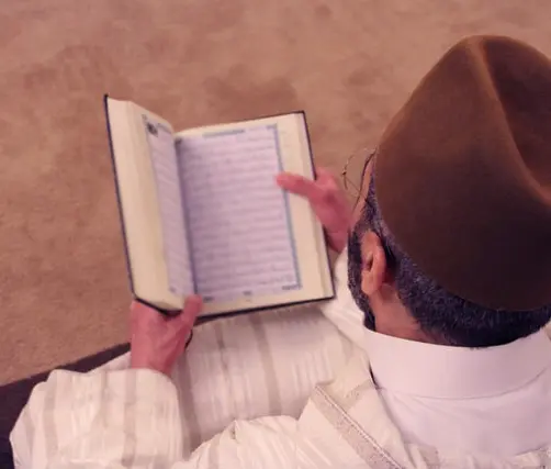 صورة تحتوي على شخص يحمل كتاباً رقم شيخ روحاني سعودي 